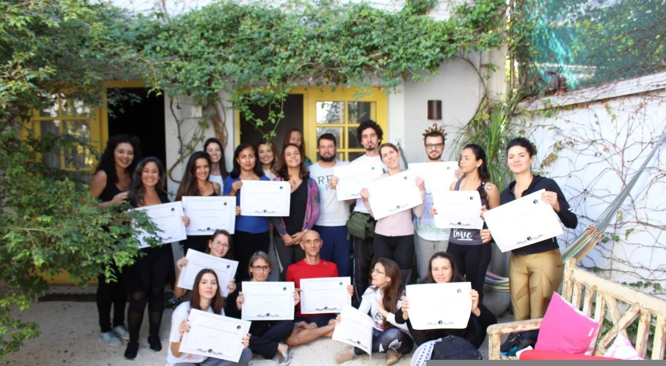 Turma de alunos formados segurando seus certificados